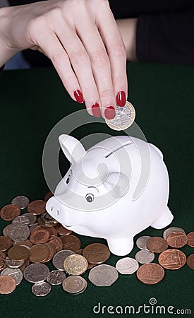 Hands placing a coin into a moneybag Stock Photo