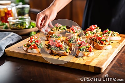 hands placing finished bruschetta on serving tray Stock Photo