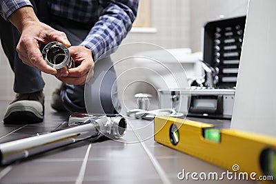 Hands plumber at work in a bathroom, plumbing repair service, as Stock Photo