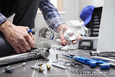 Hands plumber at work in a bathroom, plumbing repair service, as Stock Photo