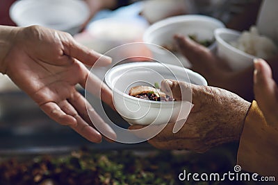 Hands of the poor receive food from the donor`s share. poverty concept Stock Photo