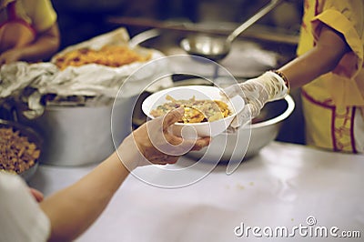 The hands of the poor receive food from the hands of the humane : the concept of relief Stock Photo