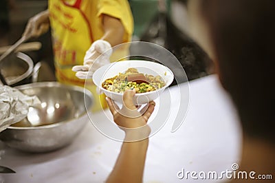 The hands of the poor receive food from the hands of the humane : the concept of relief Stock Photo