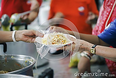 The hands of the poor receive food from the hands of the philanthropist : concept of giving Stock Photo
