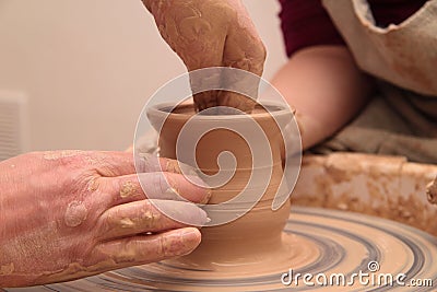 Hands of a potter, creating an earthen jar on pottery wheel. Stock Photo