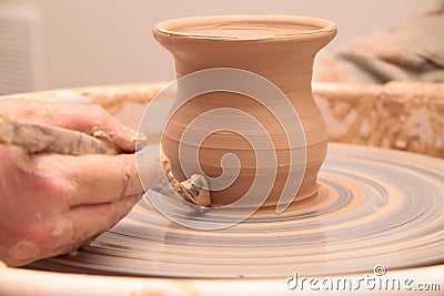 Hands of a potter, creating an earthen jar on pottery wheel. Stock Photo