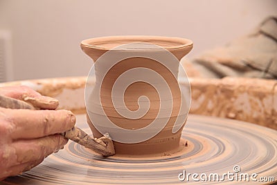 Hands of a potter, creating an earthen jar on pottery wheel. Stock Photo