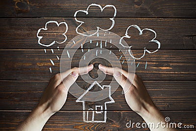 Hands protects a house from the elements - rain or storm Stock Photo