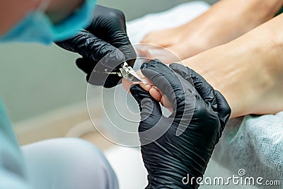 Hands of pudicurist cutting toenails of woman Stock Photo