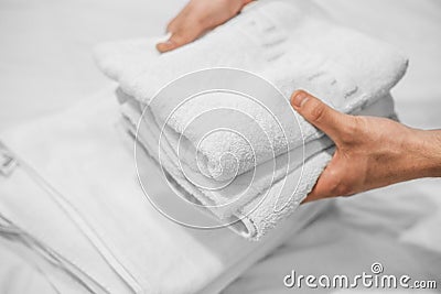 Hands put white towels on a white bed. Hotel business Stock Photo