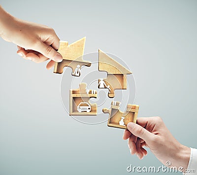 Hands putting puzzle in form house and family Stock Photo