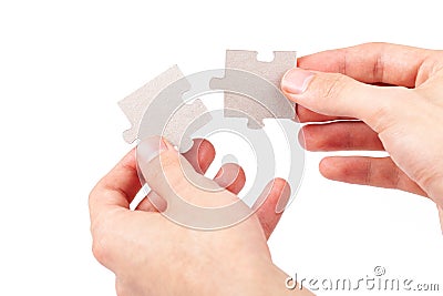 Hands putting together, connecting two matching blank jigsaw puzzle pieces, joining corresponding fitting parts, elements isolated Stock Photo