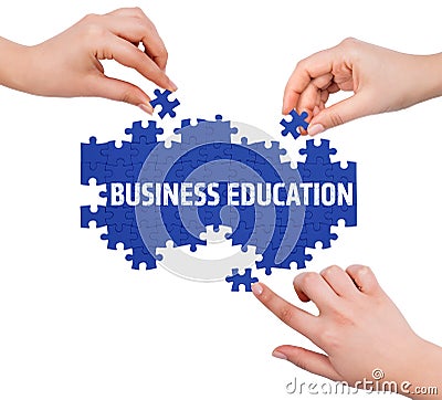 Hands with puzzle making BUSINESS EDUCATION word Stock Photo