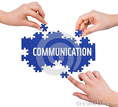 Hands with puzzle making COMMUNICATION word Stock Photo
