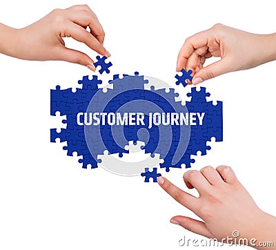 Hands with puzzle making CUSTOMER JOURNEY word Stock Photo