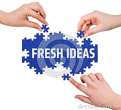 Hands with puzzle making FRESH IDEAS word Stock Photo