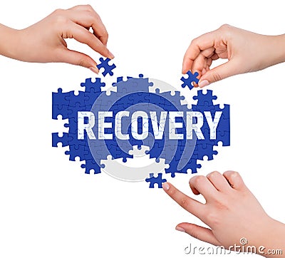 Hands with puzzle making RECOVERY word Stock Photo