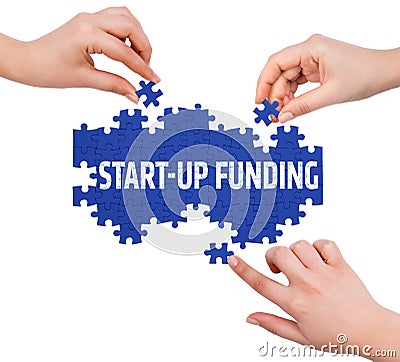 Hands with puzzle making START UP FUNDING word Stock Photo