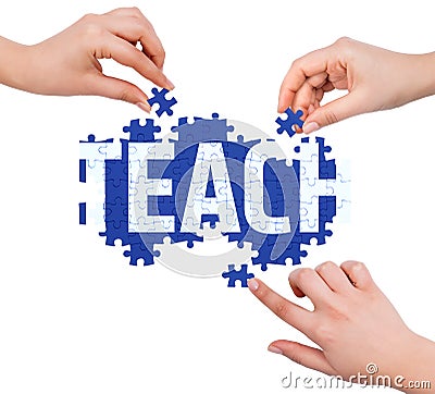 Hands with puzzle making TEACH word Stock Photo