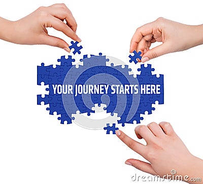 Hands with puzzle making YOUR JOURNEY STARTS HERE word Stock Photo