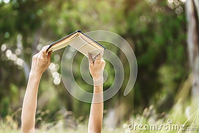 Hands raising a book up to read Stock Photo