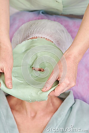 Hands removing alginate facial mask. Stock Photo