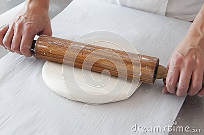 Hands with rolling pin spreading the sugar paste Stock Photo