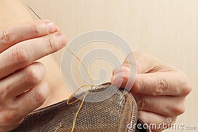 Hands of sewer repair durable cloth bag with needle close up Stock Photo
