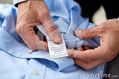 Hands with shirt and care instruction label Stock Photo