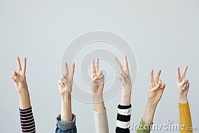 Hands showing victory sign on grey background Stock Photo