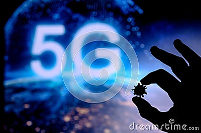 Hands silhouette holds covid 19 virus, tittle 5G in background. Conspiracy theory concept photo Stock Photo