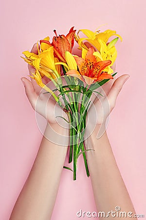 Hands and spring flowers are on a pink table skincare. Nature Cosmetics for hand skin care, a means to reduce wrinkles on hands, Stock Photo