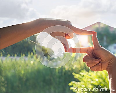 Hands symbol in front of house in sunshine nature background Stock Photo