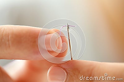 Hands of tailor woman threading needle Stock Photo