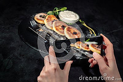 Hands taking photo a cheese pancakes with smartphone Stock Photo