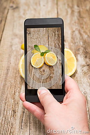 Hands taking photo of fruits on wooden. Stock Photo