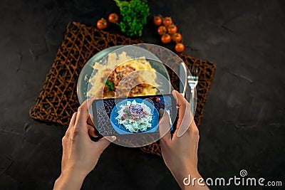 Hands taking photo Italian pasta cheese parmesan and basil with smartphone Stock Photo