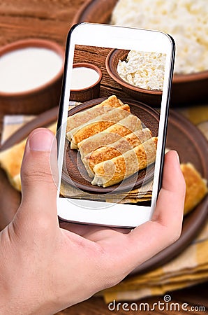 Hands taking photo pancakes with cottage cheese with smartphone. Stock Photo