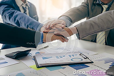 The hands of a team of businessmen joining forces celebrate the concept of unity. A close-up photo of a team working Stock Photo