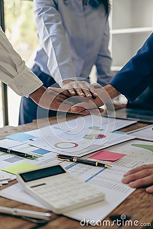 The hands of a team of businessmen joining forces celebrate the concept of unity. A close-up photo of a team working Stock Photo