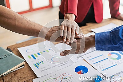 The hands of a team of businessmen joining forces celebrate the concept of unity. A close-up photo of a team working Stock Photo