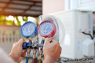 Hands of Technician are using a measuring tool to check vacuum pump evacuates air Stock Photo