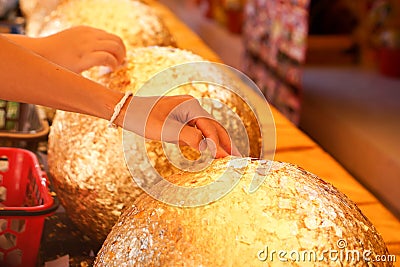 Hands of Thai people putting gold on boundary stones blessing, Stock Photo