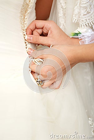 Hands tightening a corset to the bride Stock Photo