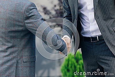 Hands of Top managers in Business Suits, shake hands with each other at Business center background. Agree to a deal or Stock Photo