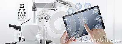 Hands touch screen of digital tablet with ophthalmologist and optometrist icons symbols, ophthalmology and optometry equipment on Stock Photo