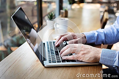 Hands typing on laptop computer keyboard, person writing email or report document in cafe with coffee and wifi internet, casual Stock Photo