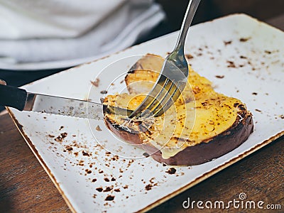 Hands using knife and fork to cut cheese toast Stock Photo