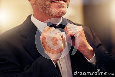 Hands, wedding and bow tie with a groom getting ready for his marriage ceremony of tradition or celebration. Fashion Stock Photo