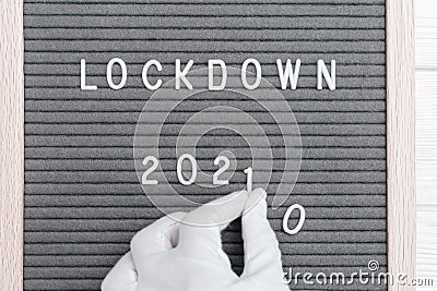 Hands in white gloves hold numder 1, replacing number zero with the number one in message text lockdown 2020 Stock Photo